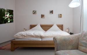 Maischeider Hof في Kleinmaischeid: سرير في غرفة مع أريكة وكرسي
