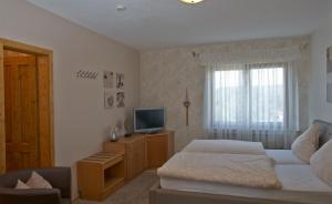 a living room with a bed and a television at Maischeider Hof in Kleinmaischeid