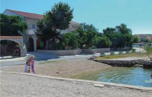 une femme debout à côté d'un étang dans une cour dans l'établissement Cozy Apartment In Kustici With Wifi, à Kustići