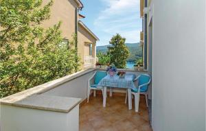 a patio with a table and chairs on a balcony at Beautiful Apartment In Rabac With Kitchen in Rabac