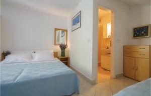 a bedroom with a blue bed and a dresser at Beautiful Apartment In Rabac With Kitchen in Rabac