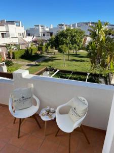 two white chairs sitting on a balcony with a view at Casa Beau Murcia, Condado de Alhama in El Romero