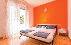 1 dormitorio con paredes de color naranja y 1 cama con ventana en Cozy Apartment In Makarska With Kitchen en Makarska