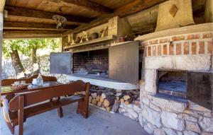 a stone fireplace with a bench in front of it at Pet Friendly Home In Moscenice With Kitchen in Mošćenice