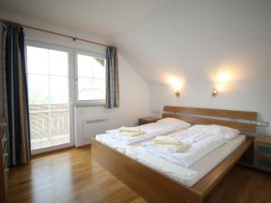 1 dormitorio con 1 cama con sábanas blancas y ventana grande en Holiday home in Salzburg Lungau near the ski slope en Sankt Margarethen im Lungau