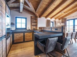 a kitchen with a large black counter and chairs at Luxurious holiday home in Piesendorf with sauna in Piesendorf