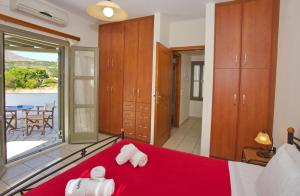 a bedroom with a red bed with a view of the ocean at To Pithari in Skiros