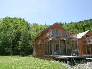 a large wooden house in a field with trees at Chalet in Stadl an der Mur Styria with sauna in Stadl an der Mur