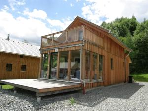 a wooden house with glass windows and a bench at Chalet in Stadl an der Mur Styria with sauna in Stadl an der Mur