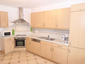 a kitchen with wooden cabinets and a sink at Luxurious Mansion in Goldegg near Skiing Area in Goldegg