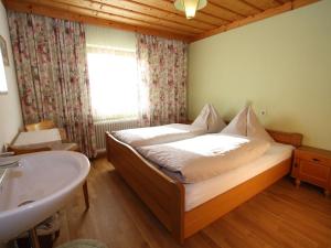 - une chambre avec un lit, un lavabo et une fenêtre dans l'établissement Beautiful Holiday Home in Filzmoos with Sauna, à Filzmoos
