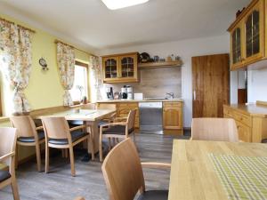 uma cozinha com armários de madeira e uma mesa e cadeiras em Beautiful Holiday Home in Filzmoos with Sauna em Filzmoos