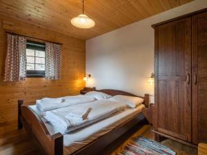シュラニツェンにあるApartment on the Sonnenalpe in Nassfeldの木製の部屋に大型ベッドが備わるベッドルーム1室が備わります。