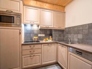 a kitchen with white cabinets and a sink and a microwave at Apartment on the Sonnenalpe in Nassfeld in Schlanitzen