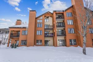 an apartment building with snow in front of it at Pico C103 in Killington