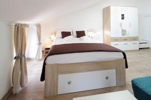 ein Schlafzimmer mit einem großen Bett mit einem Holzrahmen in der Unterkunft Centrally located studio apartment Seagull in Rijeka