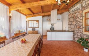 a kitchen and dining room with a table and a stone wall at Stunning Home In Rovinj With 6 Bedrooms, Wifi And Outdoor Swimming Pool in Rovinj