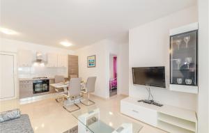 uma sala de estar branca com uma mesa e uma televisão em 2 Bedroom Lovely Apartment In Biograd em Biograd na Moru