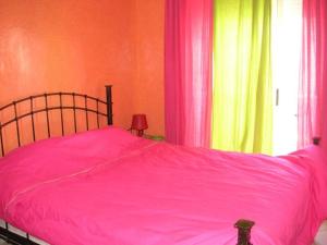 a bedroom with a pink bed and a window at Appartement Marhaba in Agadir