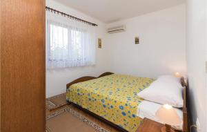 a small bedroom with a bed and a window at Amazing Apartment In Zadar With 2 Bedrooms And Wifi in Zadar