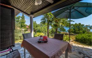 stół z parasolem na patio w obiekcie Holiday Home Labin 57 w mieście Drenje