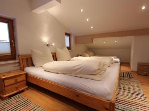 a bedroom with a large bed with white sheets and pillows at Nice apartment in Westendorf Tyrol near ski area in Westendorf