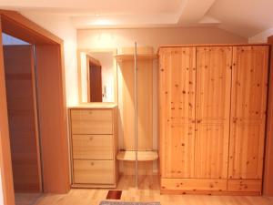 a closet with a wooden cabinet and a mirror at Nice apartment in Westendorf Tyrol near ski area in Westendorf
