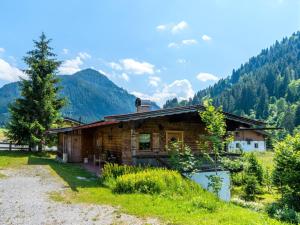 une cabane en rondins avec un arbre dans les montagnes dans l'établissement Chalet in Kirchberg with terrace and garden, à Aschau