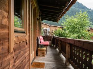 - une terrasse couverte en bois avec 2 chaises sur le côté de la maison dans l'établissement Chalet in Kirchberg with terrace and garden, à Aschau