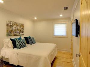 a bedroom with a bed with pillows on it at Downtown Fairhope Cottage in Fairhope
