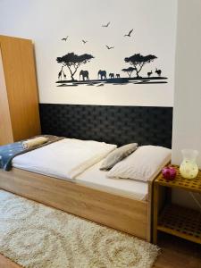 a bedroom with a bed with animals on the wall at Origo Apartman in Eger