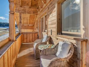 a porch of a cabin with chairs and a window at Captivating Holiday Apartment in Ellmau in Ellmau