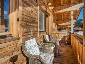 a porch of a cabin with wicker chairs at Captivating Holiday Apartment in Ellmau in Ellmau