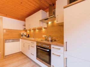 a kitchen with white appliances and a wooden ceiling at Cozy apartment in Wald K nigsleiten in Wald im Pinzgau