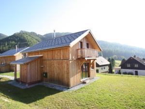 una gran casa de madera en un campo de hierba en Nice chalet in Hohentauern Styria with sauna, en Hohentauern