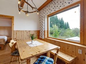 ein Esszimmer mit einem Holztisch und einem Fenster in der Unterkunft Cosy holiday home with private pool in Eberstein