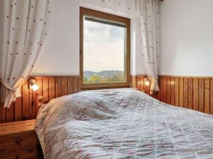 sypialnia z dużym łóżkiem i oknem w obiekcie Cosy holiday home with private pool w mieście Eberstein