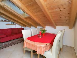 アシャウにあるApartment with terrace in Aschau im Zillertalのダイニングルーム(赤いテーブル、白い椅子付)