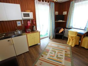 a kitchen with a refrigerator and a table in a room at Apartment in Feld am See with lake access in Feld am See