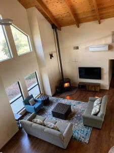 a living room with two couches and a flat screen tv at Yosemite Riverside Retreat with small beach access and air conditioning in Oakhurst