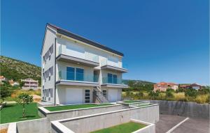 ein großes weißes Haus mit einem Hof in der Unterkunft Beautiful Apartment In Trogir With Kitchen in Trogir