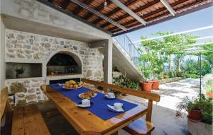 an outdoor dining room with a table and a pizza oven at Beautiful Apartment In Brsecine With Kitchen in Brsečine
