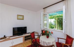 a living room with a table and a television at Beautiful Apartment In Brsecine With Kitchen in Brsečine