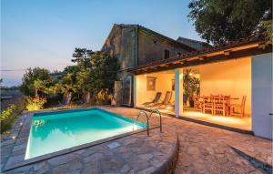 a house with a swimming pool in front of a house at Beautiful Home In Domijanici With Outdoor Swimming Pool in Žminj