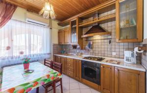 a kitchen with a table and a stove top oven at Awesome Apartment In Vodnjan With 2 Bedrooms And Outdoor Swimming Pool in Vodnjan