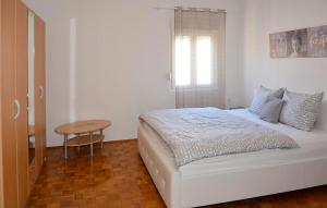 a white bedroom with a bed and a table at Stunning Apartment In Senj With Wifi in Senj