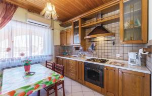 une cuisine avec une table et une cuisinière four supérieur dans l'établissement Apartment Peroj Ii, à Vodnjan
