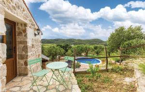 a patio with a table and chairs and a pool at 2 Bedroom Awesome Home In Supetarska Draga in Supetarska Draga