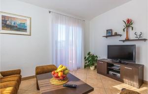 a living room with a television and a bowl of fruit on a table at 1 Bedroom Amazing Apartment In Bribir in Bribir