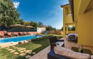 un patio trasero con una piscina con sillas y una mesa en Cozy Home In Medulin With Kitchen, en Medulin 36 fotos más